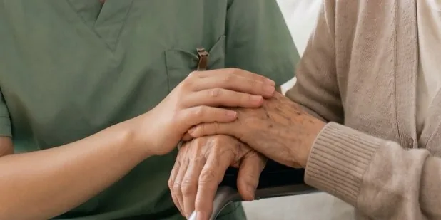 護理師雙手握住長輩的手 / A nurse\'s hands around an older person\'s hand