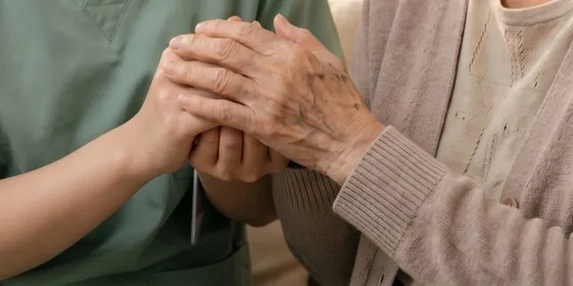 護理師握著長輩的手 / A nurse holding an older person\'s hands